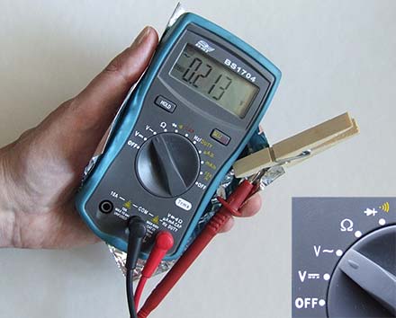 A hand holding a multimeter.
